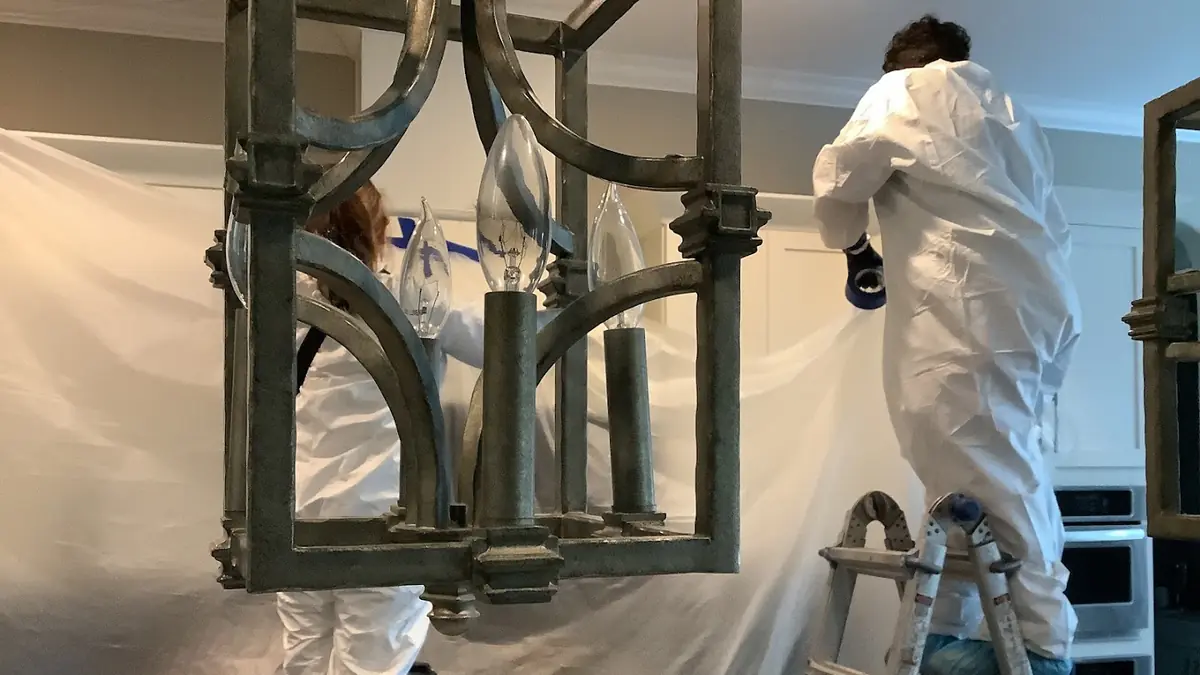 Technician in a protective suit on a ladder