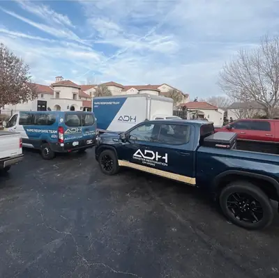 ADH Disaster Restoration branded trucks in a parking lot