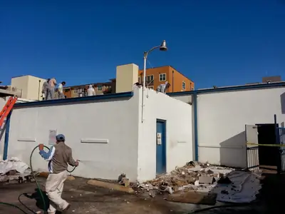 Worker clearing debris outside a building