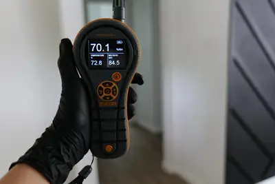 Moisture meter reading in a gloved hand