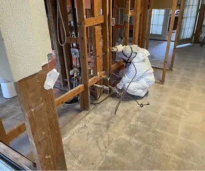 Technician in a protective suit in a stripped room