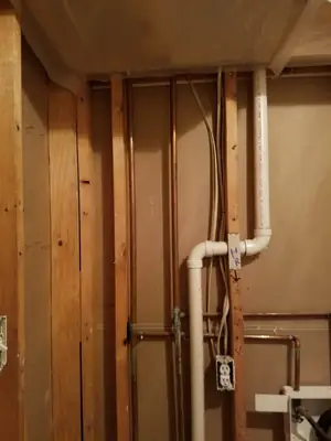 Wall opened to expose plumbing