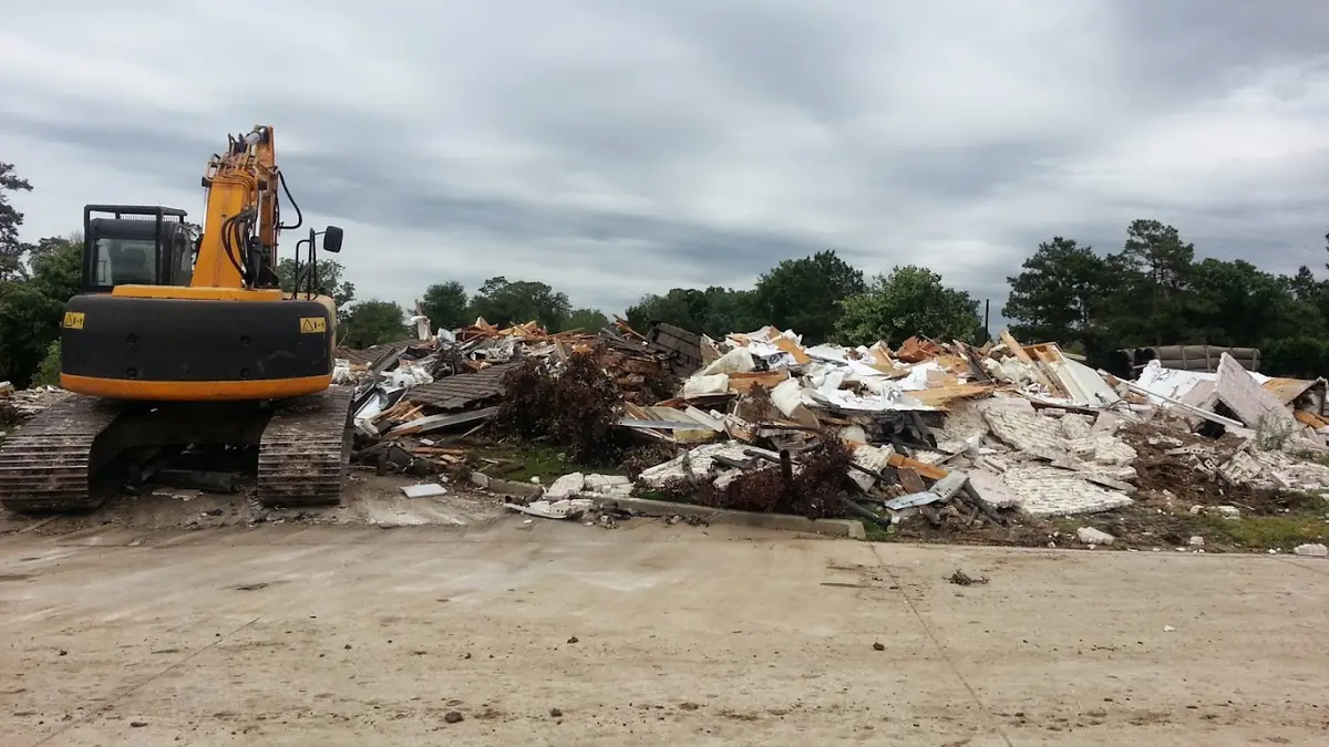 Excavator and demolition debris on a cleared site