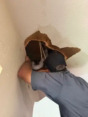 Technician cutting into drywall