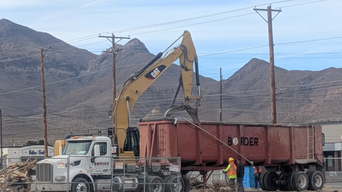 Excavator loading a dump truck on a demolition job