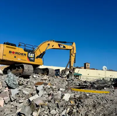 Excavator on a pile of rubble