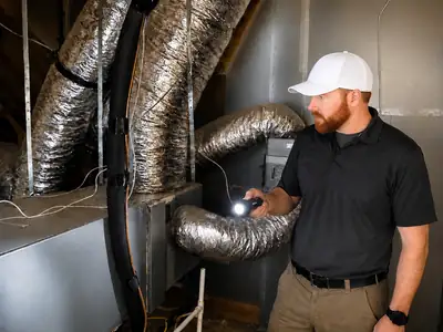 Inspector examining attic ductwork