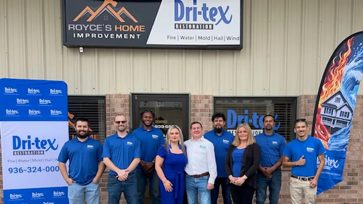 The Dri-Tex Restoration team in front of a company banner
