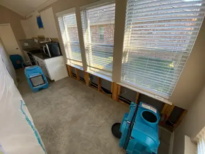 Air movers drying a room by a window