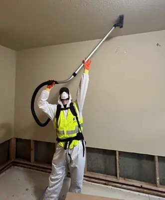 Technician in protective gear working on a ceiling