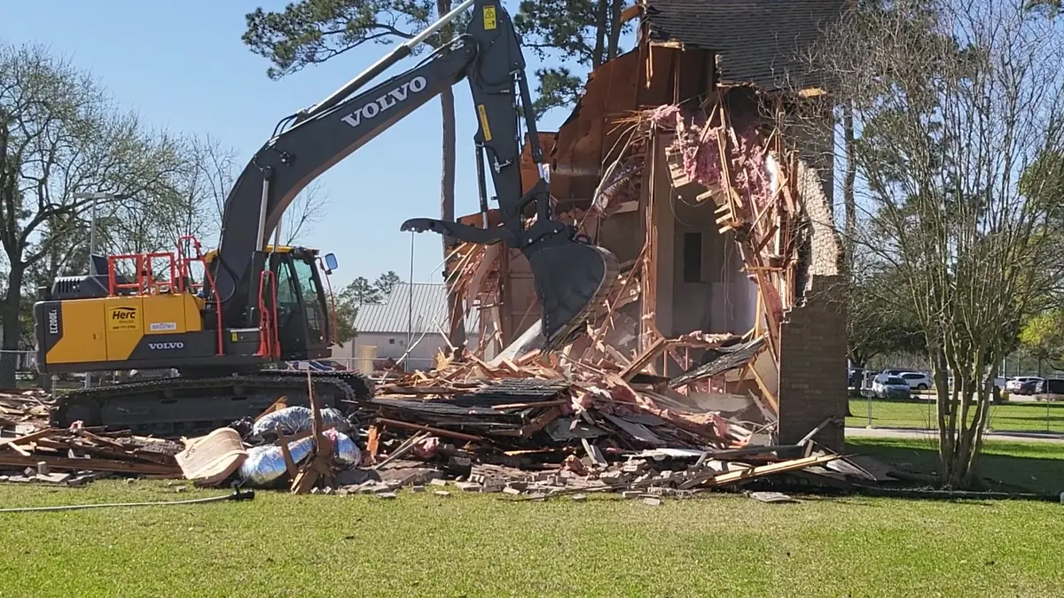 Excavator demolishing a house