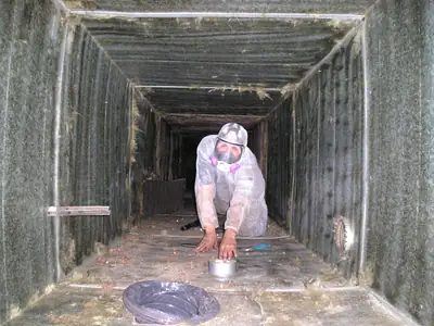 Technician cleaning inside a large air duct