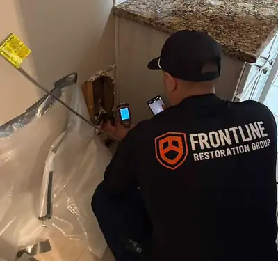 Technician in a Frontline Restoration Group shirt at work