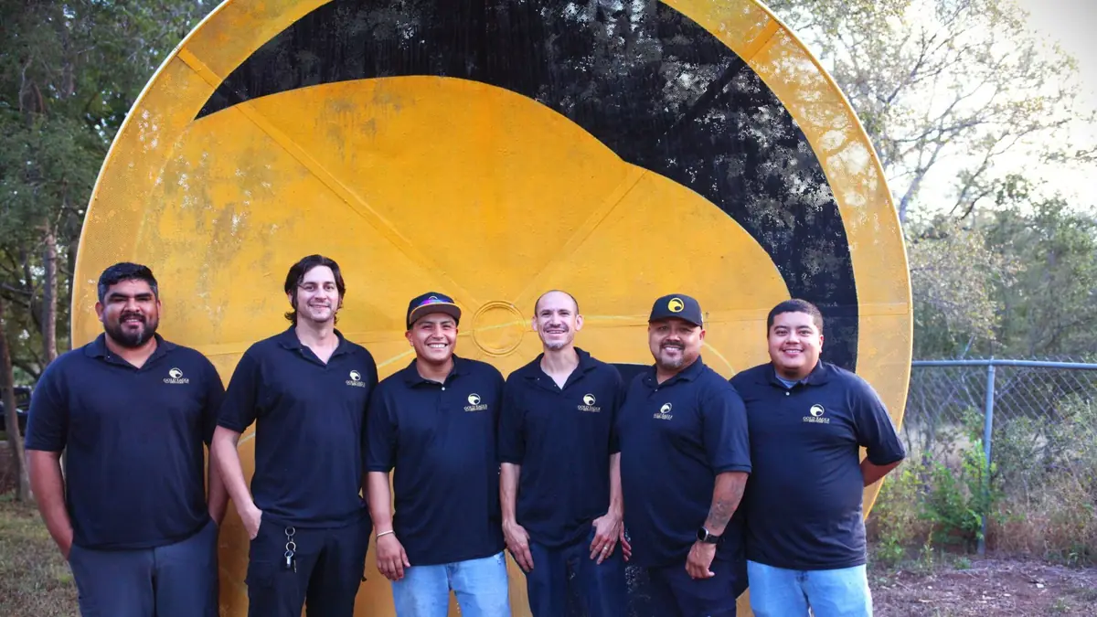 The Gold Eagle Services team in front of the company sign