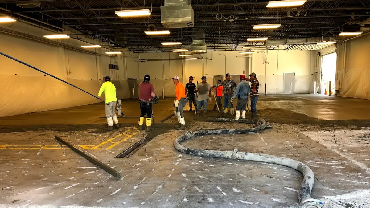 Crew working on a concrete floor inside a building