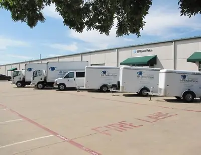 Fleet of white work trucks and trailers