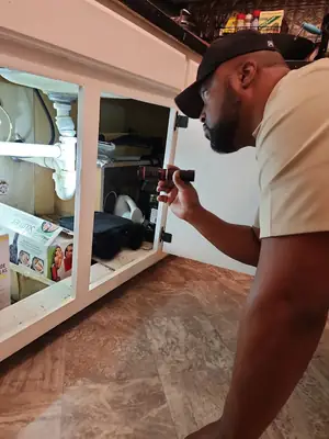 Inspector checking under a sink