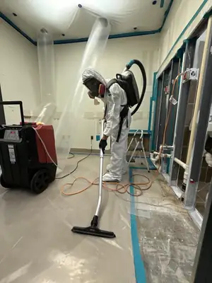 Technician in a protective suit vacuuming