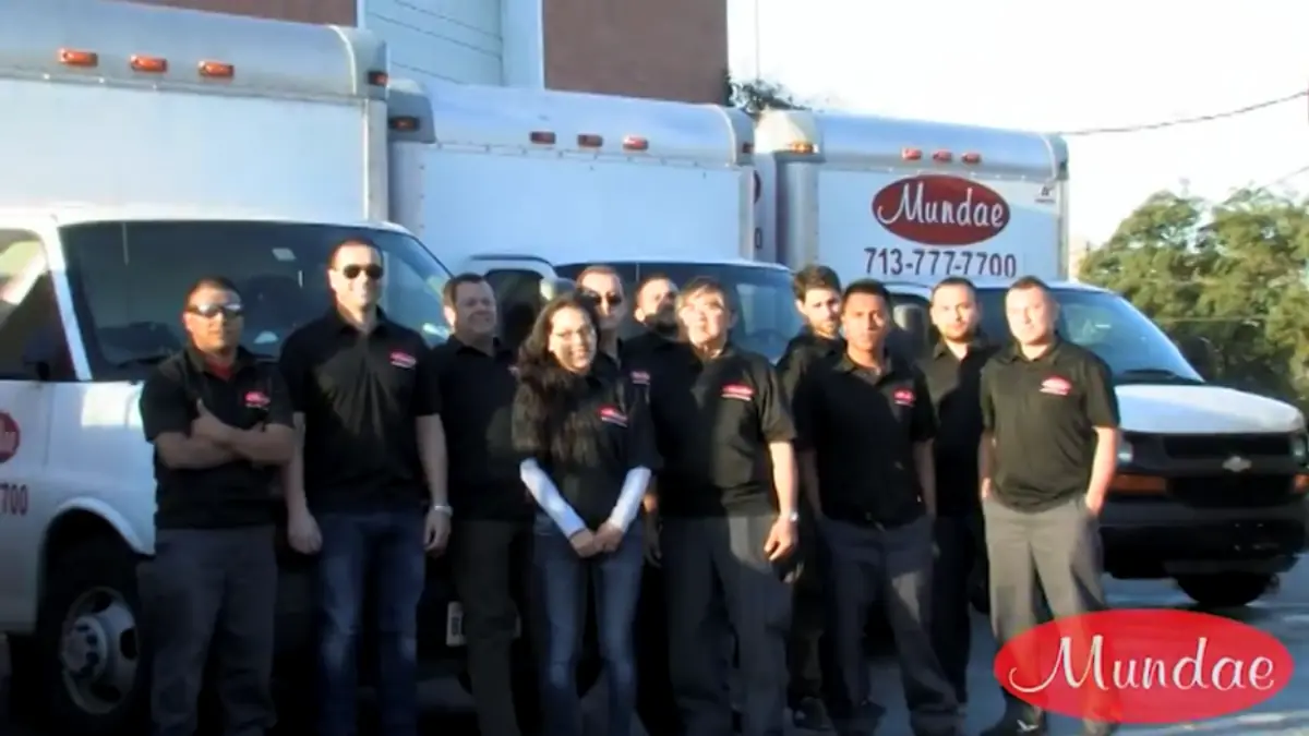 Mundae Cleaning & Restoration - Downtown Houston crew in branded shirts in front of company vans