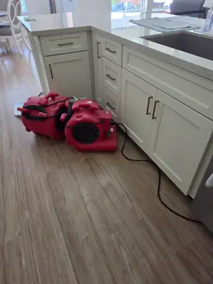 Air movers drying a kitchen