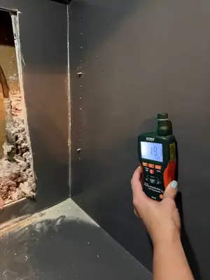 Moisture meter against a wall