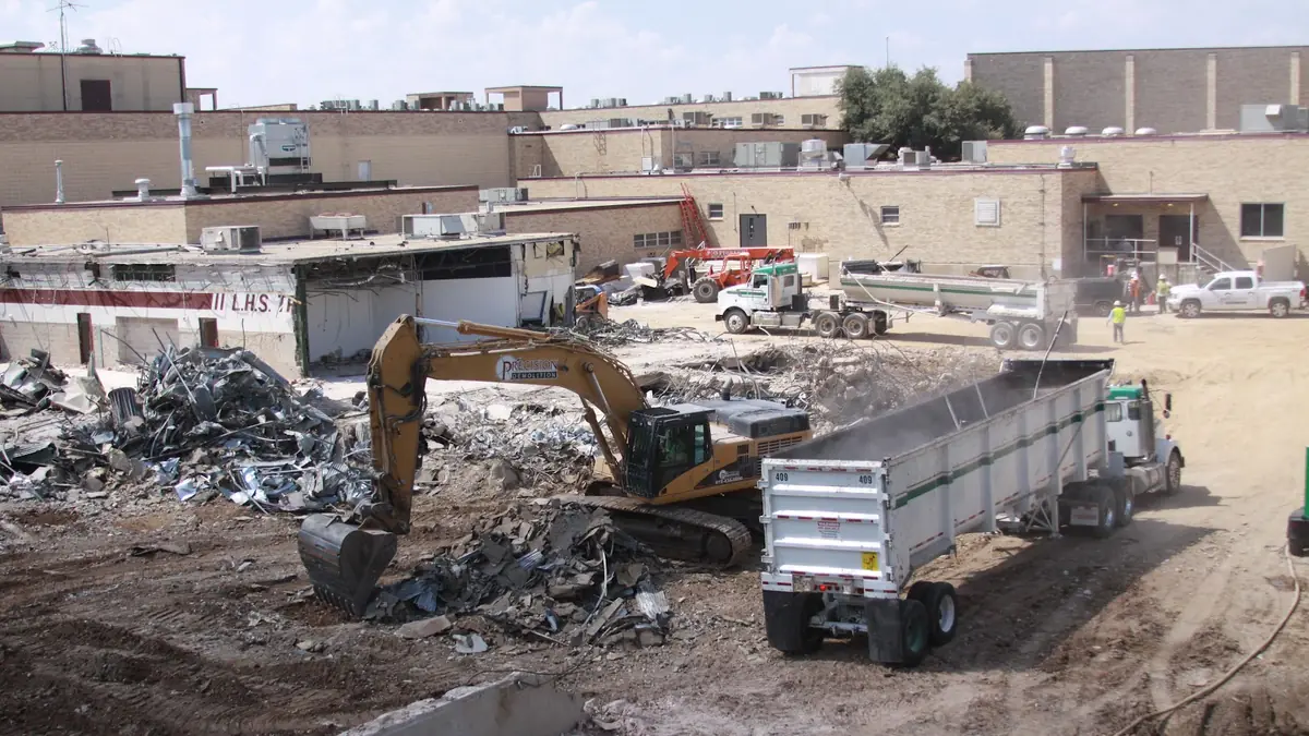 Excavator loading debris into a truck
