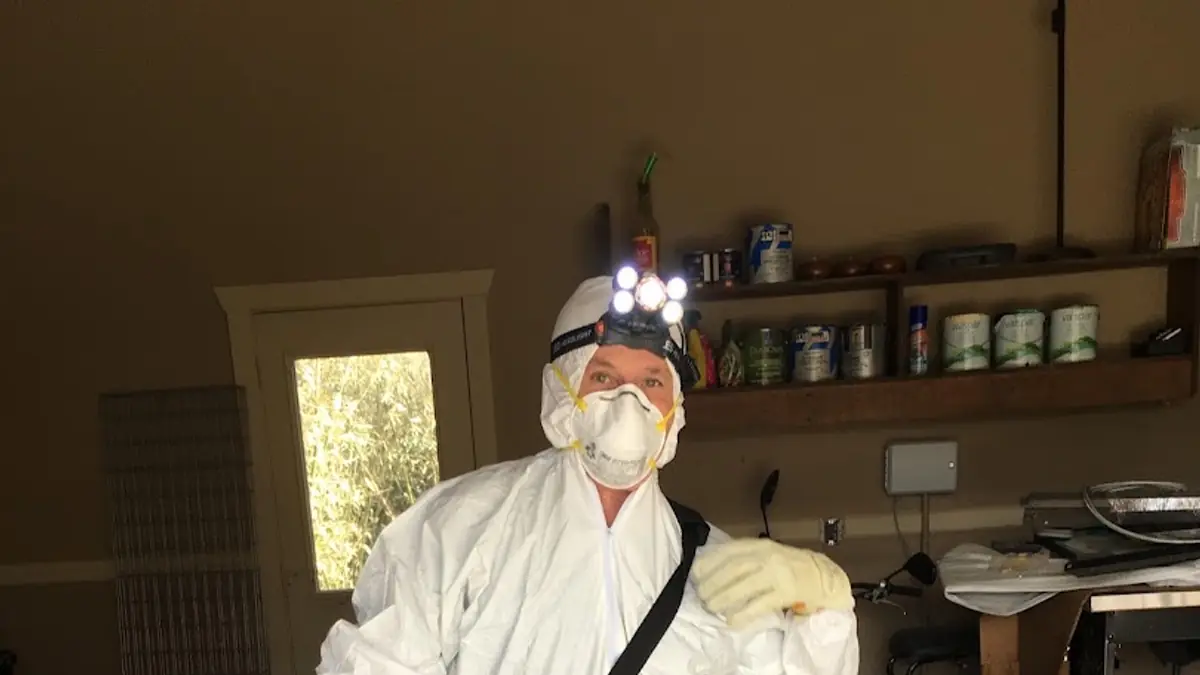 Technician in a full protective suit inside a home