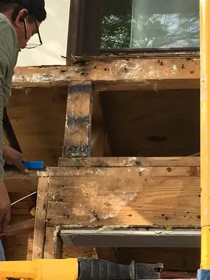 Rotted wood framing exposed under a window