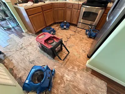 Air movers drying a kitchen