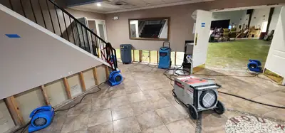 Air movers along a stripped staircase wall