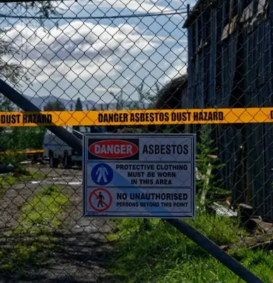 Asbestos warning signs on a site fence