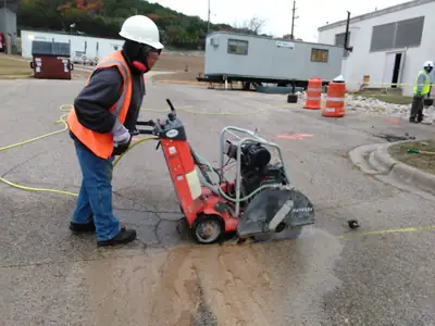 Worker cutting concrete with a saw