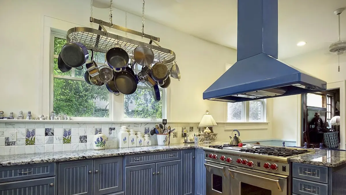 Finished kitchen with a range hood and pot rack