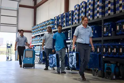 The SS Water Restoration team in a warehouse full of drying equipment