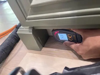 Moisture meter probe at a cabinet base