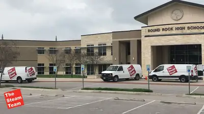 The Steam Team vans outside a school building