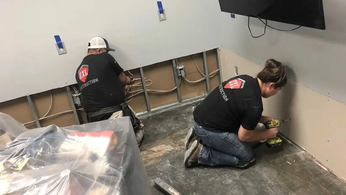 Two technicians working on a floor inside containment