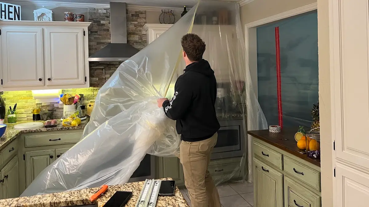 Technician working beside containment in a kitchen