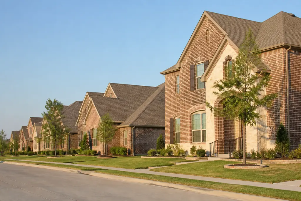 Two-story red brick family homes on a suburban street, typical of Dallas–Fort Worth